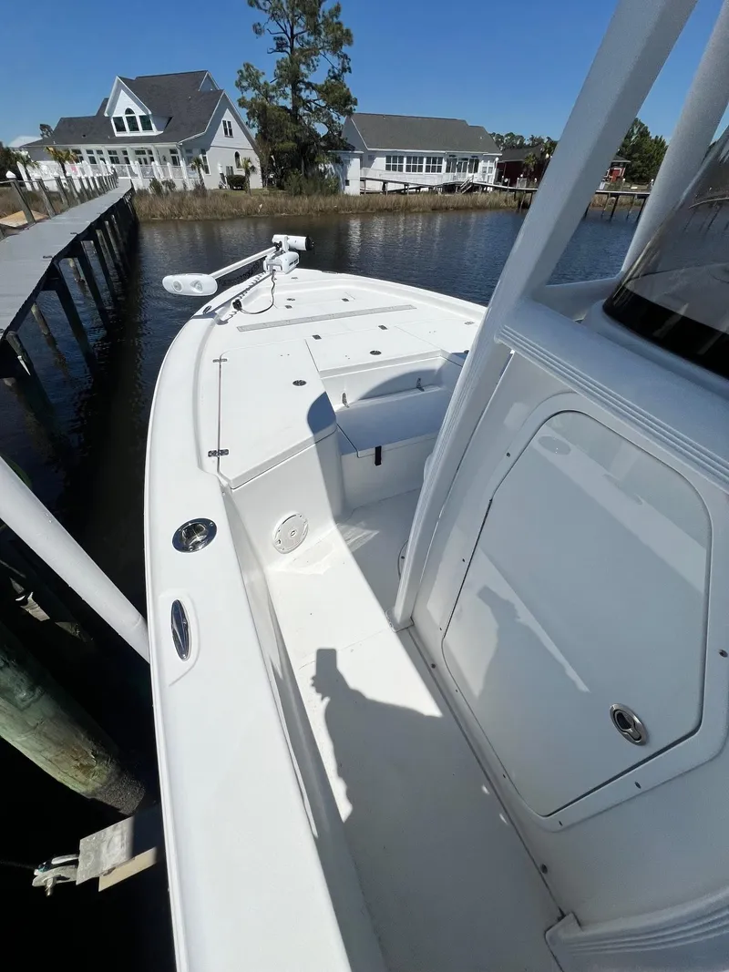 Slide: The Image of 2015 Sea Hunt BX 22 BR boat docked by waterfront homes, sunny day. - 11