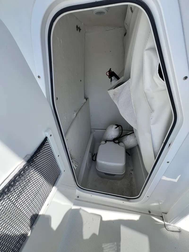 Slide: The Image of 2015 Sea Hunt BX 22 BR boat storage compartment with equipment and netting. - 12