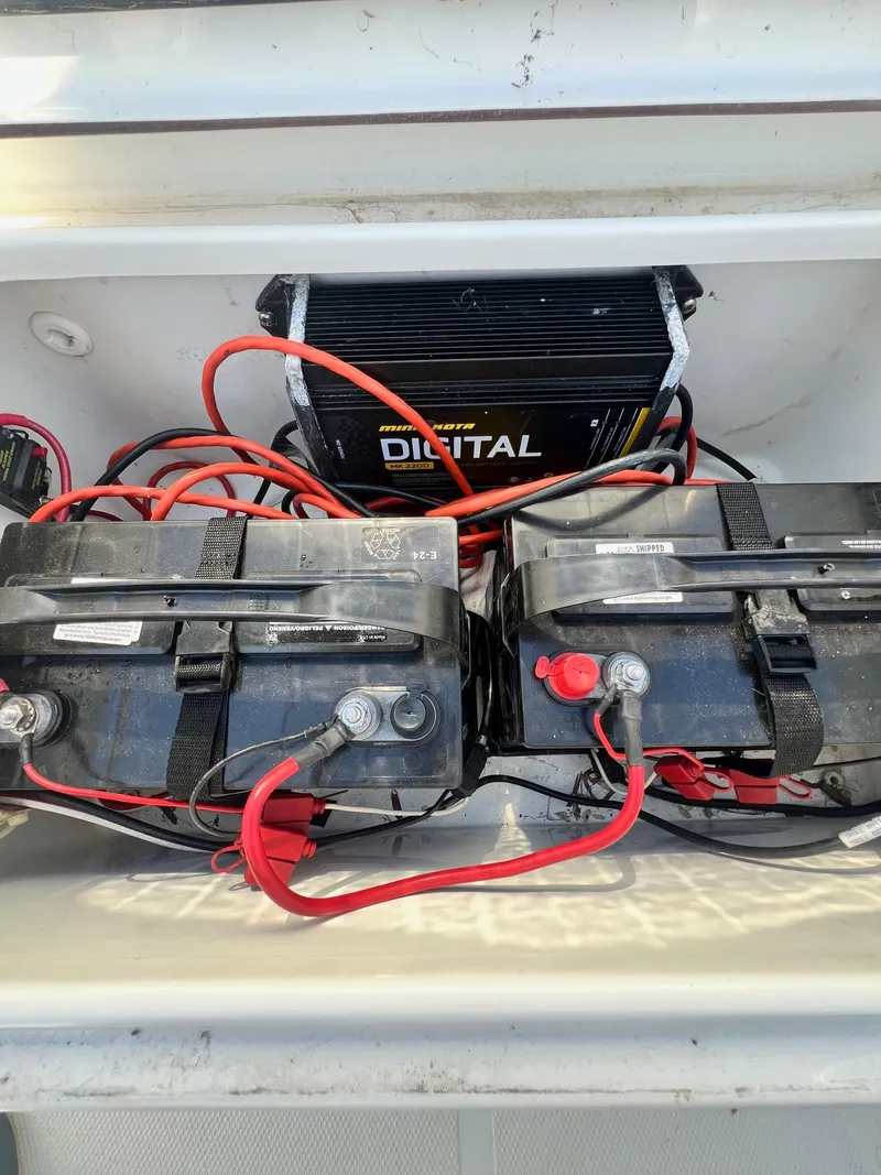 Slide: The Image of 2015 Sea Hunt BX 22 BR boat battery compartment with dual batteries and charger. - 16