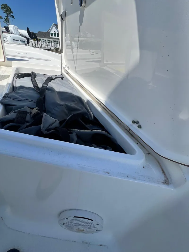 Slide: The Image of Open storage compartment on 2015 Sea Hunt BX 22 BR boat, showing interior contents. - 17