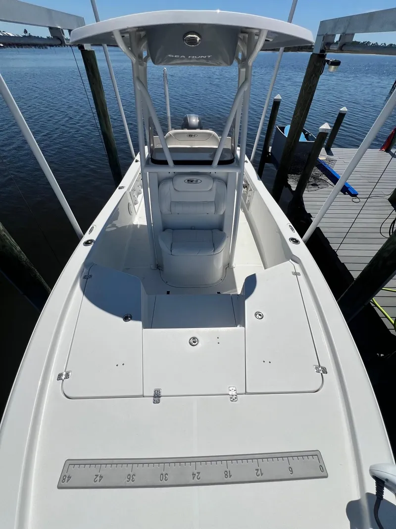 Slide: The Image of 2015 Sea Hunt BX 22 BR boat docked, featuring a spacious deck and T-top. - 18