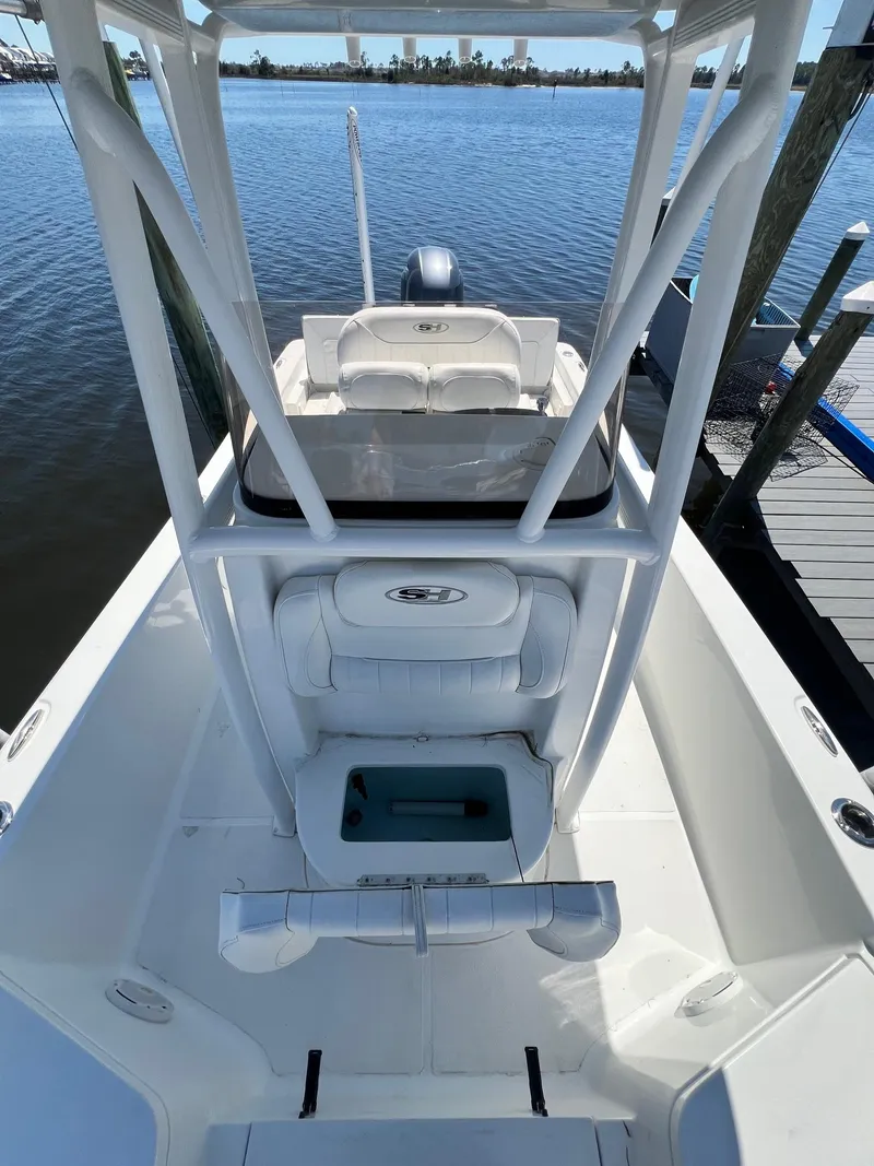 Slide: The Image of 2015 Sea Hunt BX 22 BR boat with T-top, docked on calm water. - 19