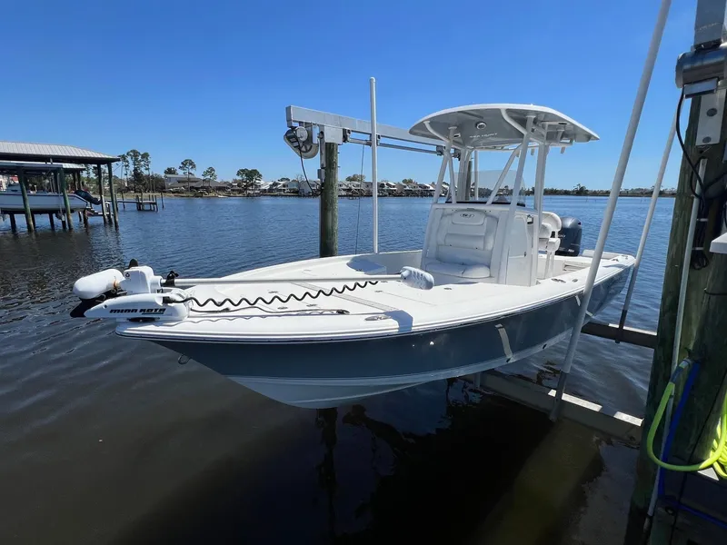 Slide: The Image of 2015 Sea Hunt BX 22 BR boat docked on calm water under clear blue sky. - 2