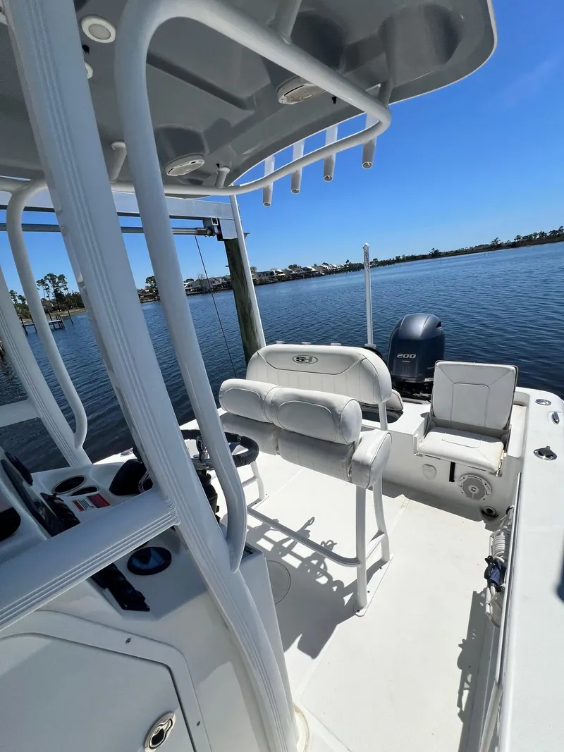 Slide: The Image of 2015 Sea Hunt BX 22 BR boat on calm water, featuring seating and console. - 21