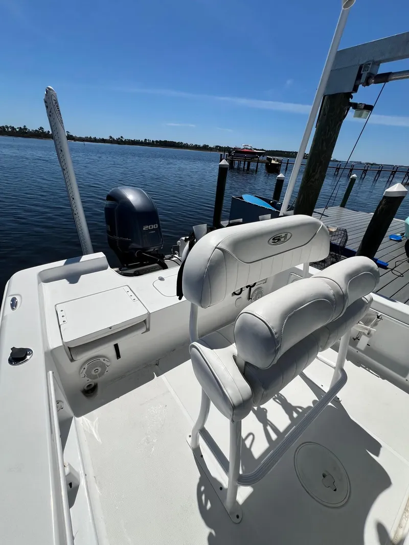 Slide: The Image of 2015 Sea Hunt BX 22 BR boat docked by a serene waterfront. - 22