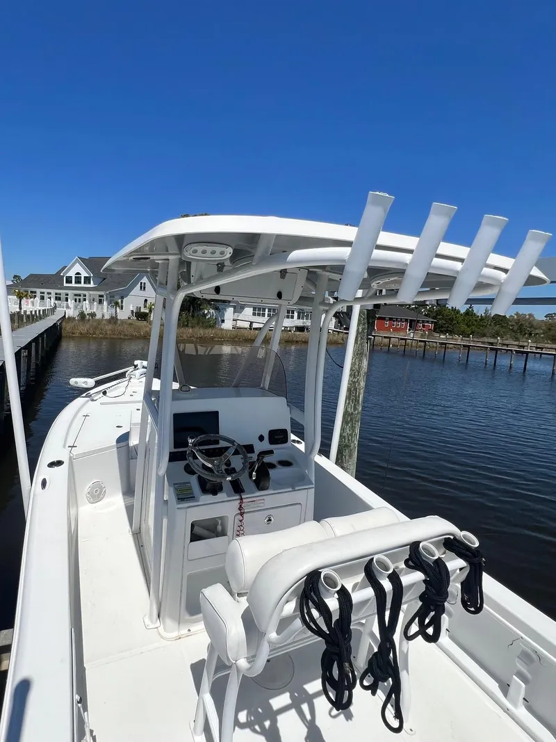 Slide: The Image of 2015 Sea Hunt BX 22 BR boat docked by waterfront homes under clear blue sky. - 26