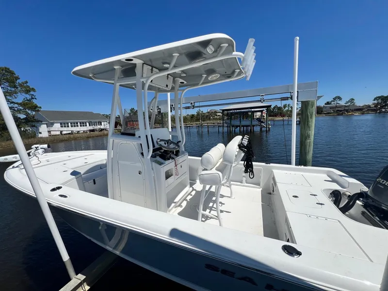 Slide: The Image of 2015 Sea Hunt BX 22 BR boat docked by the water, featuring a center console and T-top. - 4