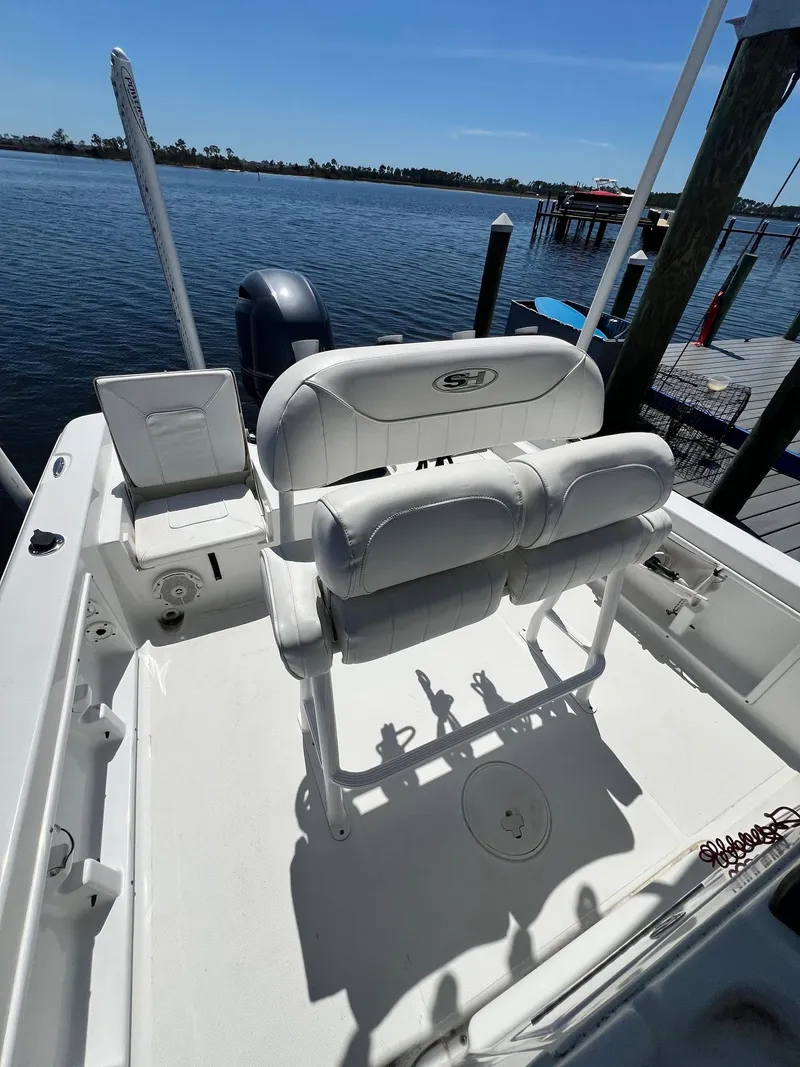 Slide: The Image of 2015 Sea Hunt BX 22 BR boat with white seating, docked by a calm waterfront. - 6