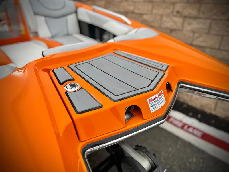 Slide: The Image of 2015 MasterCraft XStar boat with orange and gray detailing, featuring a sleek deck design. - 11