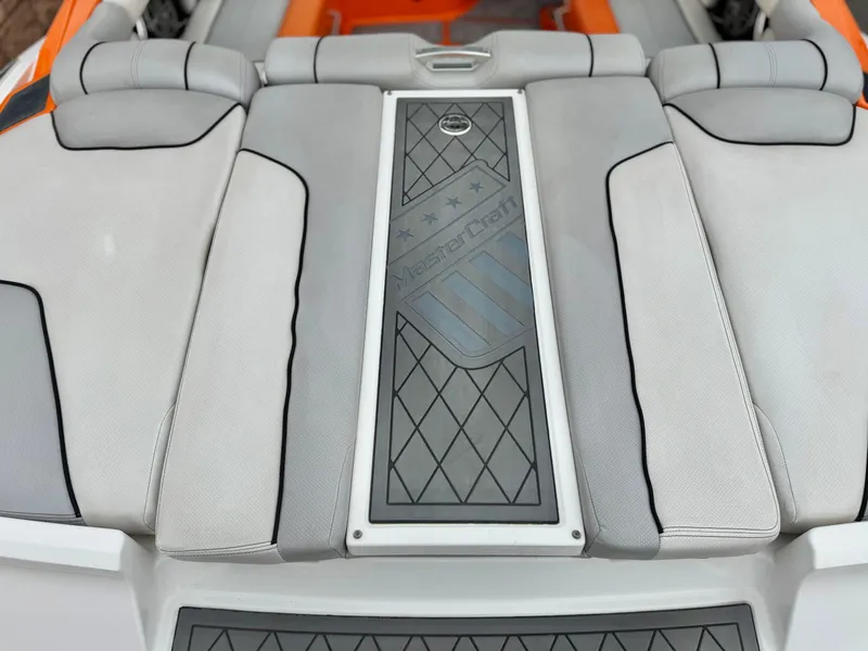 Slide: The Image of 2015 MasterCraft XStar boat interior with gray and orange seating, featuring diamond-patterned design. - 15