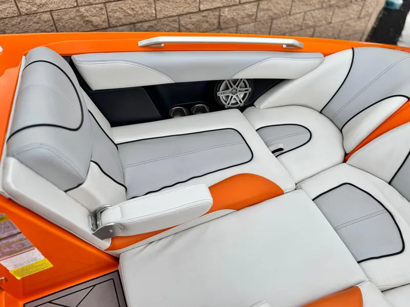 Slide: The Image of 2015 MasterCraft XStar boat interior with orange and white seating, featuring sleek design and speaker detail. - 20