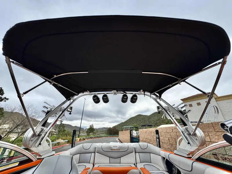 Slide: The Image of 2015 MasterCraft XStar boat with black canopy and sleek interior design. - 23