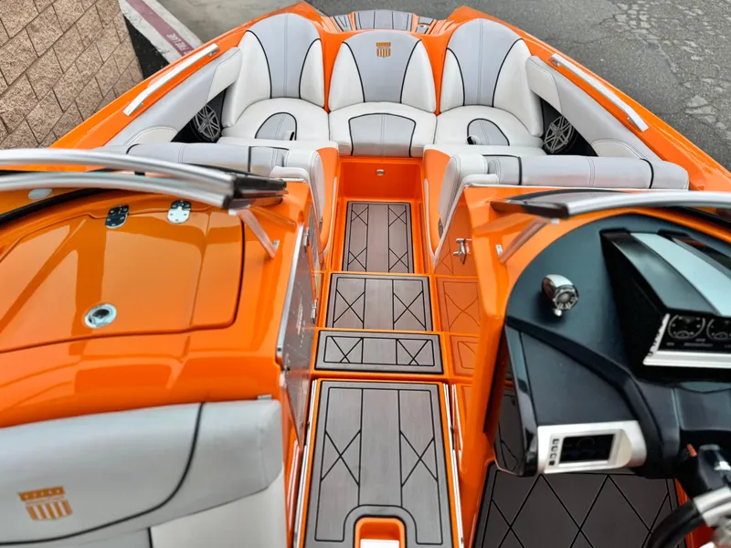 Slide: The Image of 2015 MasterCraft XStar boat interior with orange and gray seating and sleek dashboard design. - 24