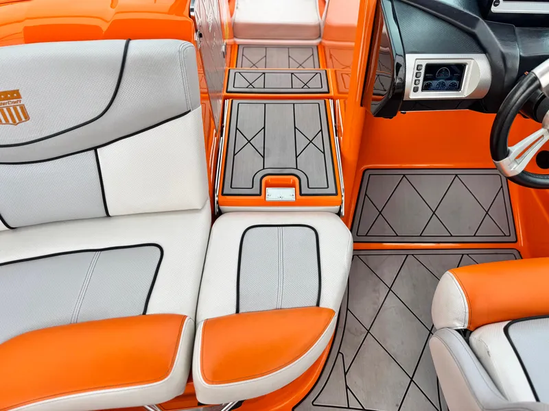 Slide: The Image of 2015 MasterCraft XStar interior with orange and gray seating and modern dashboard design. - 27