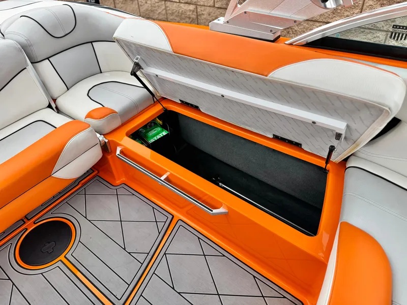 Slide: The Image of 2015 MasterCraft XStar interior with orange and gray seating, open storage compartment. - 34
