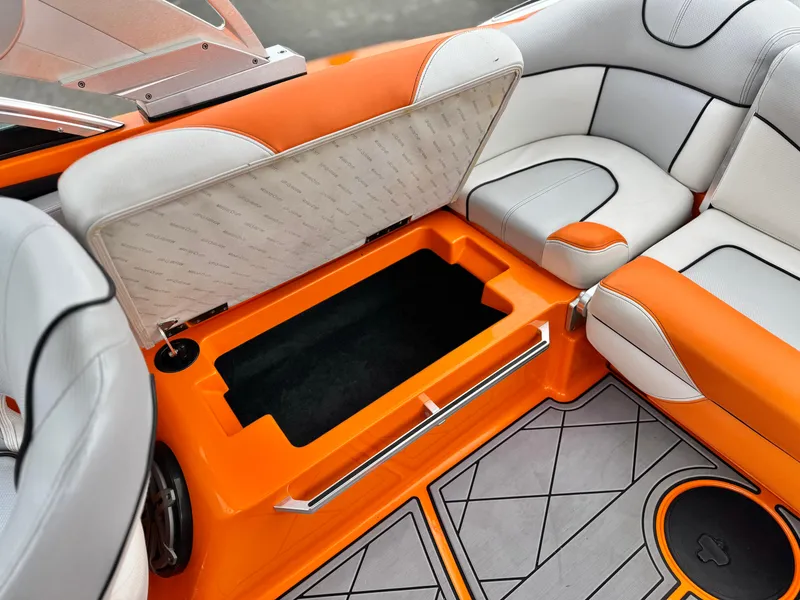 Slide: The Image of 2015 MasterCraft XStar interior with orange and white seating, open storage compartment. - 36