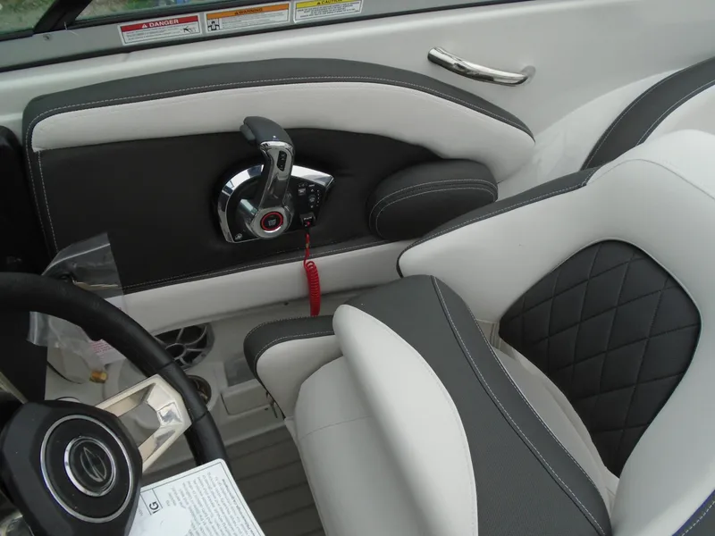 Slide: The Image of 2024 Crownline E 240 XS boat interior with steering wheel and throttle control. - 12