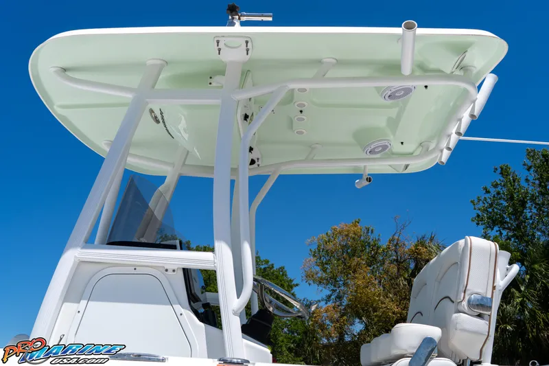 Slide: The Image of 2019 Sea Hunt Ultra 234 boat with T-top and seating, under clear blue sky. - 13