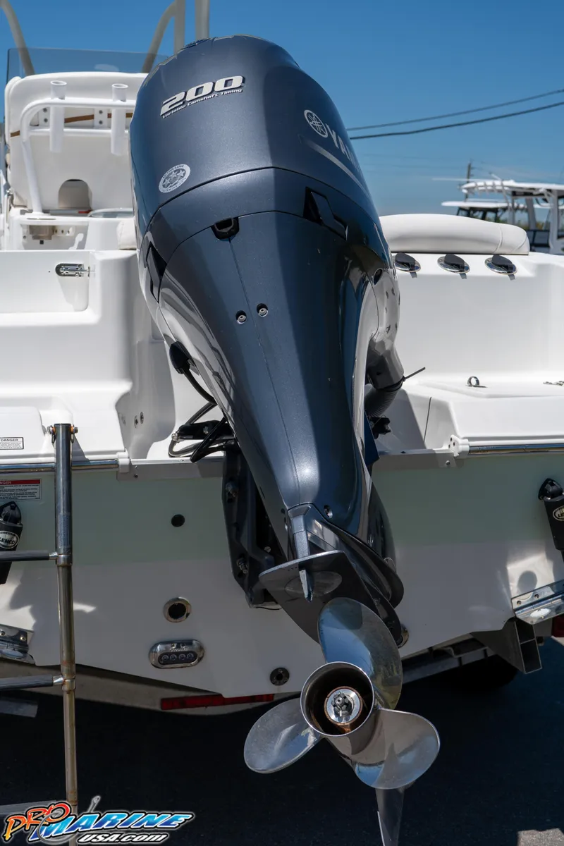 Slide: The Image of 2019 Sea Hunt Ultra 234 boat with powerful outboard motor, docked under clear blue sky. - 15