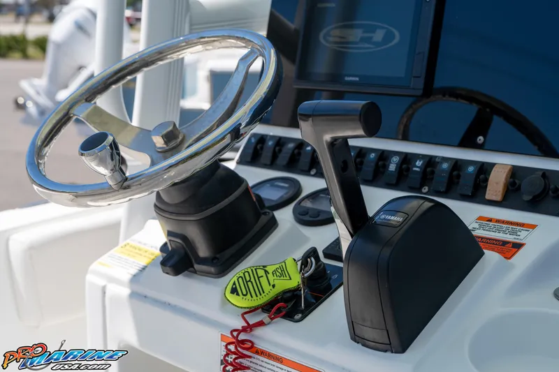 Slide: The Image of Steering console of 2019 Sea Hunt Ultra 234 boat with controls and keychain. - 22