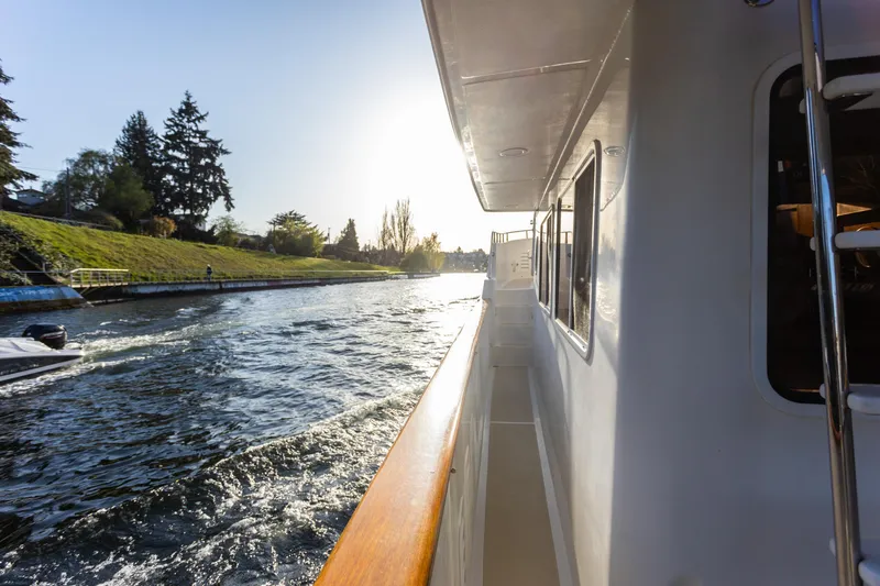Slide: The Image of Side view of a 2003 Selene 47 yacht cruising on a sunny river. - 14