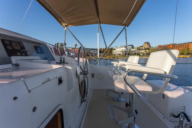 Slide: The Image of Helm of 2003 Selene 47 yacht with dual seats and steering wheel, docked by waterfront. - 22