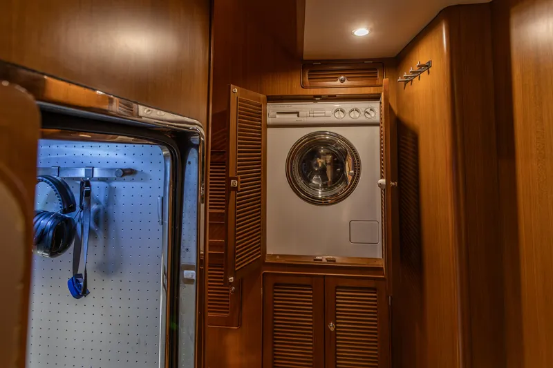 Slide: The Image of Laundry area with washer in 2003 Selene 47 yacht, featuring wooden cabinetry and ambient lighting. - 31