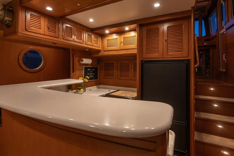 Slide: The Image of Luxurious 2003 Selene 47 yacht interior with wooden cabinetry and modern kitchen amenities. - 4