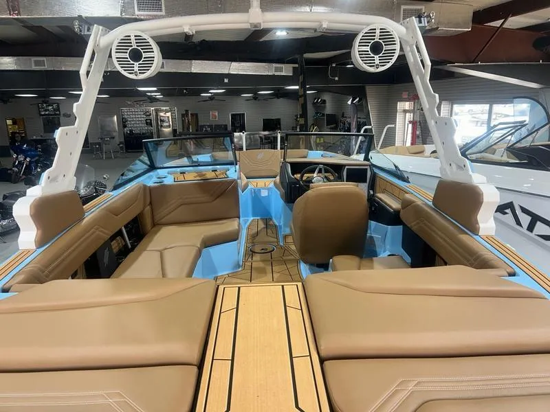 Slide: The Image of 2025 ATX Surf Boats 20 Type-S interior with tan seating and blue accents in showroom. - 3