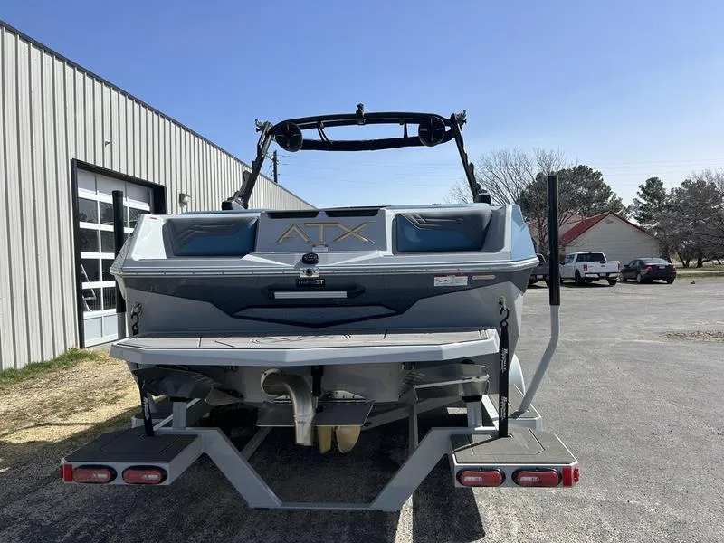 Slide: The Image of 2025 ATX Surf Boats 22 Type-S, rear view, parked outdoors near a building. - 1