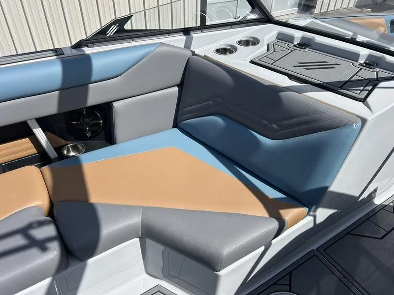 Slide: The Image of 2025 ATX Surf Boats 22 Type-S interior with blue and tan seating, cup holders, and sleek design. - 4