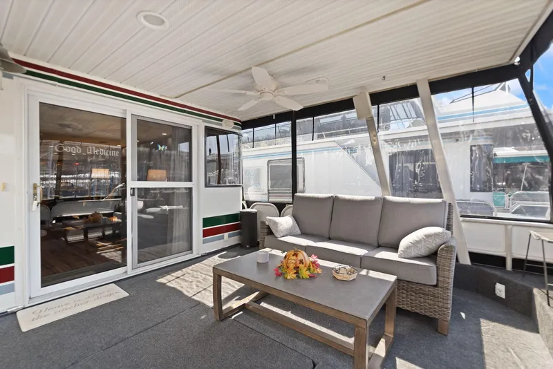 Slide: The Image of 1998 Sharpe 16 X 80 Widebody Houseboat with cozy outdoor seating area and sliding glass doors. - 14