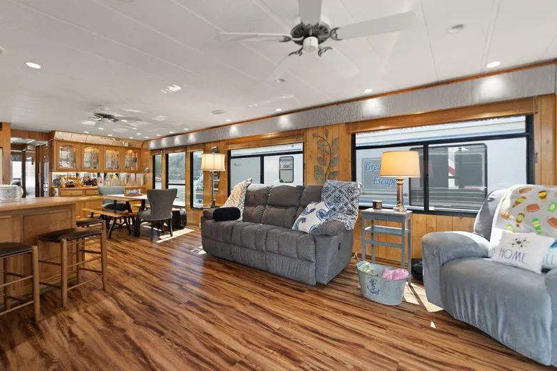 Slide: The Image of Interior of a 1998 Sharpe 16 X 80 Widebody Houseboat with cozy seating and wooden flooring. - 28