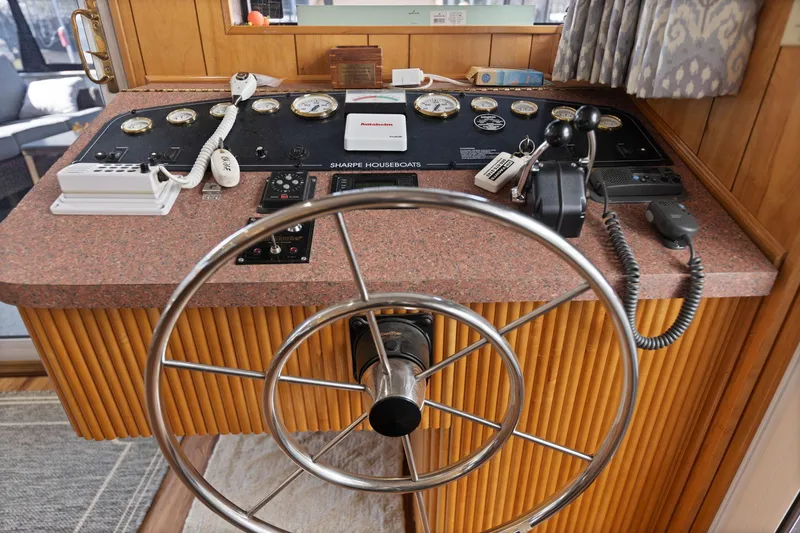 Slide: The Image of 1998 Sharpe 16 X 80 Widebody Houseboat helm with steering wheel and control panel. - 35