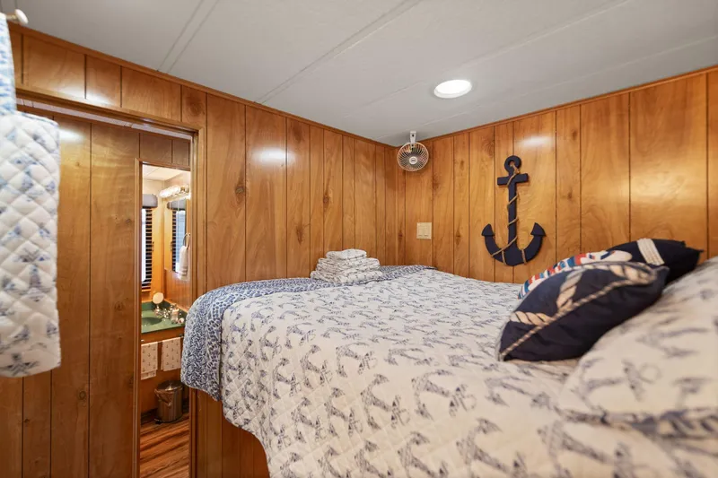 Slide: The Image of Cozy bedroom in 1998 Sharpe houseboat with nautical decor and wood paneling. - 41