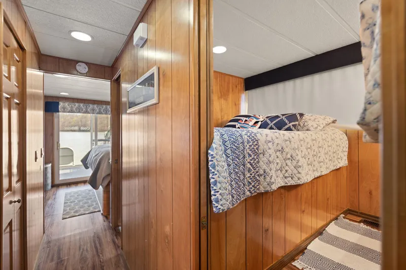 Slide: The Image of 1998 Sharpe houseboat interior with wood paneling, bunk beds, and hallway view. - 42