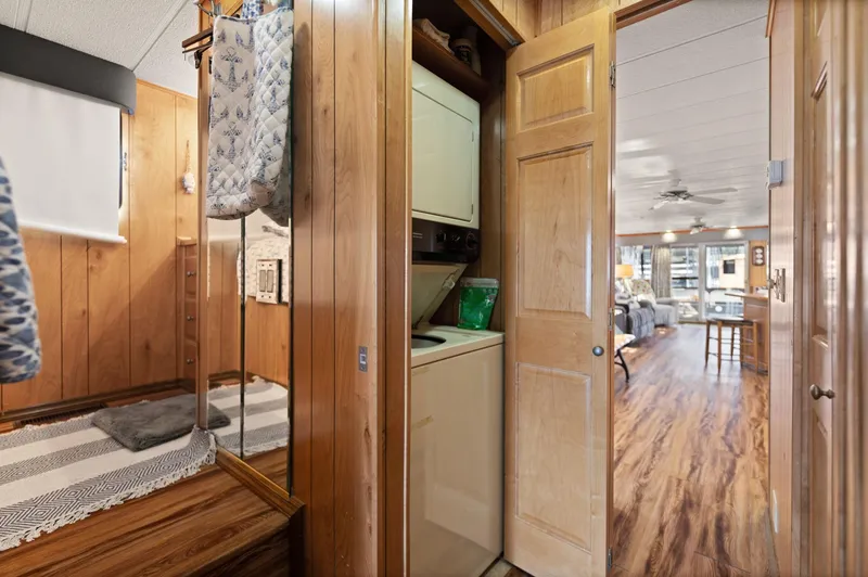 Slide: The Image of 1998 Sharpe houseboat interior with wood paneling, laundry area, and open living space. - 44
