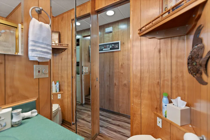 Slide: The Image of 1998 Sharpe houseboat bathroom with wood paneling, mirror, and green countertop. - 48