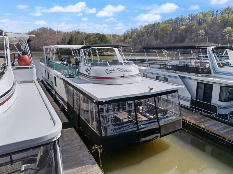 Slide: The Image of 1998 Sharpe 16 X 80 Widebody Houseboat docked on a calm lake under a blue sky. - 5