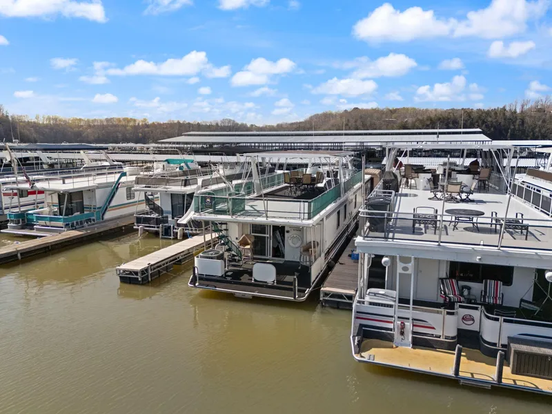 Slide: The Image of 1998 Sharpe 16 X 80 Widebody houseboat docked at a marina under a clear blue sky. - 7