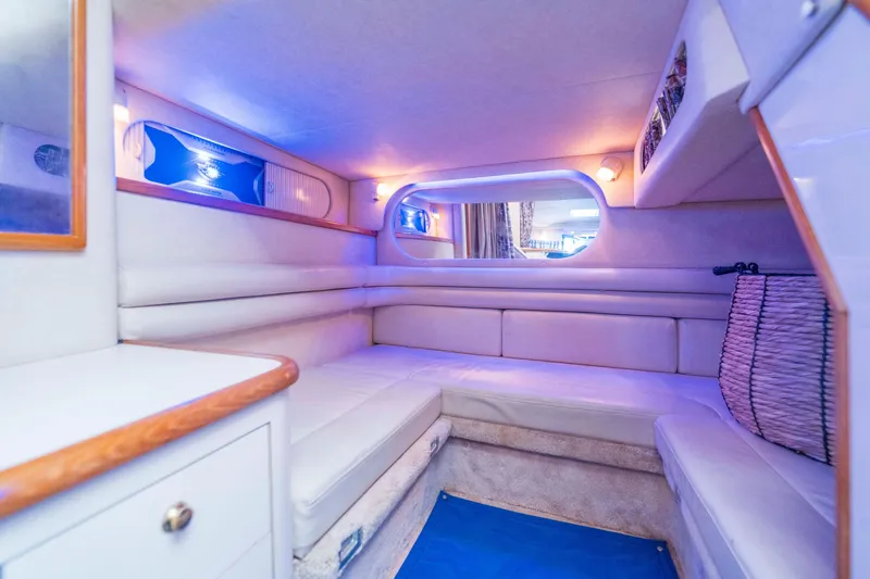 Slide: The Image of 1997 Sea Ray 330 Sundancer cabin with white seating and ambient lighting. - 11