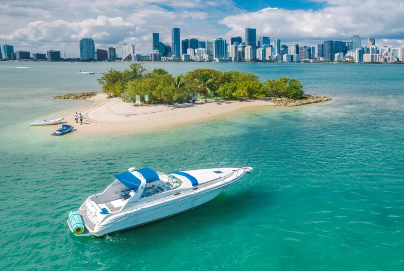 Slide: The Image of 1997 Sea Ray 330 Sundancer near tropical island with city skyline in background. - 4