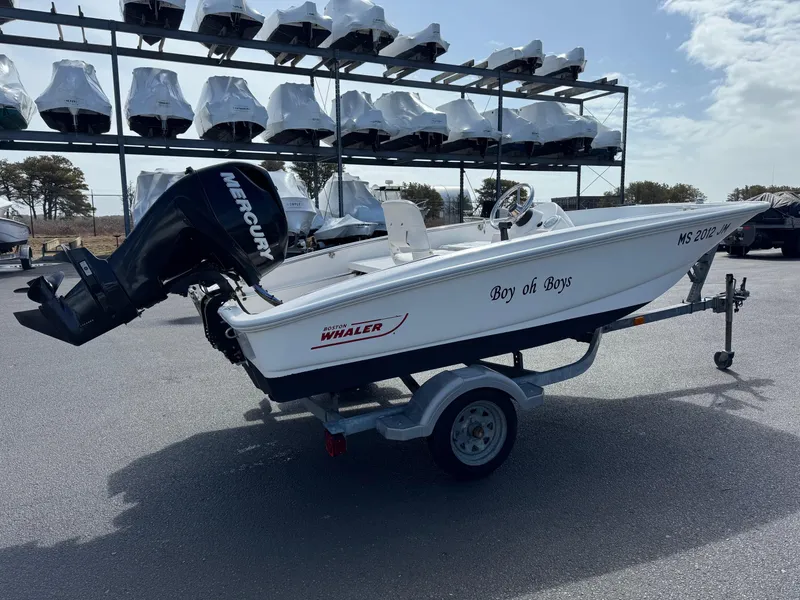 Slide: The Image of 2012 Boston Whaler 130 Super Sport boat on trailer, outdoor storage background. - 4