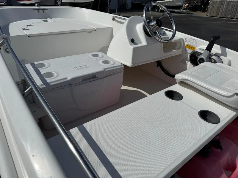 Slide: The Image of 2012 Boston Whaler 130 Super Sport interior with steering wheel and seating area. - 8