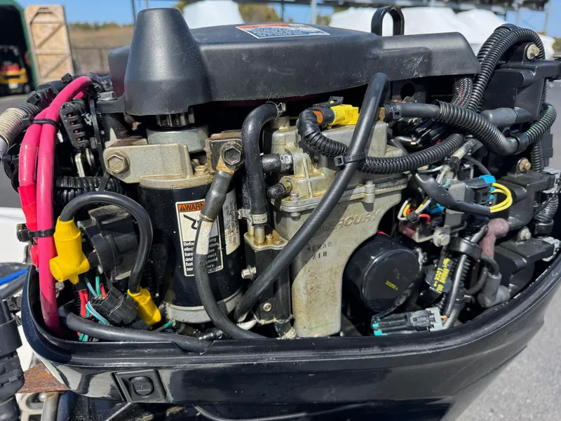 Slide: The Image of Close-up of a 2012 Boston Whaler 130 Super Sport engine with visible wiring and components. - 9