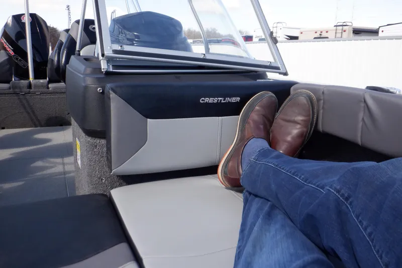 Slide: The Image of 2022 Crestliner 1950 Super Hawk boat interior with person relaxing, feet up. - 11