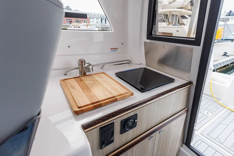 Slide: The Image of Compact kitchen area in 2026 Solara S-250 Coupe with sink, cutting board, and stove. - 17