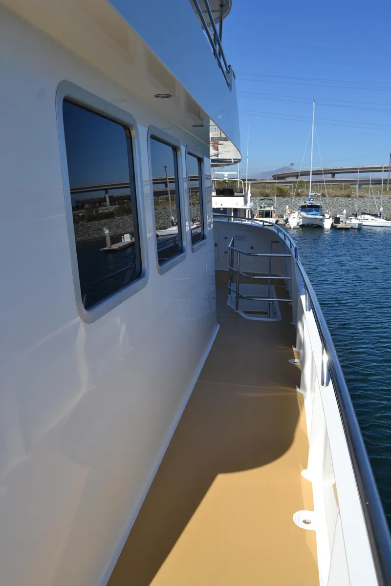 Slide: The Image of Side deck view of 2018 Allseas Expedition yacht, docked in a marina under clear blue skies. - 14