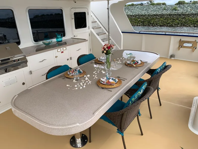 Slide: The Image of Outdoor dining area on 2018 Allseas Expedition yacht with elegant table setting and wicker chairs. - 17