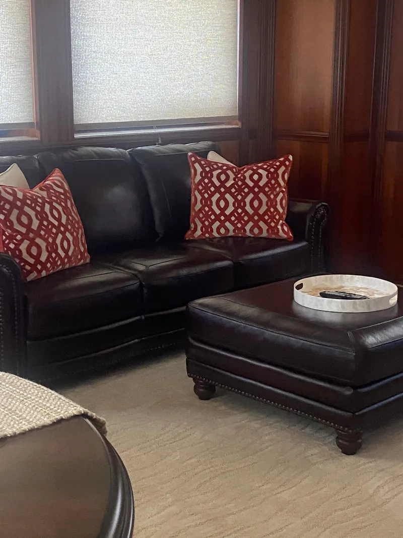 Slide: The Image of Luxurious leather sofa with red patterned pillows in a 2018 Allseas Expedition interior. - 21